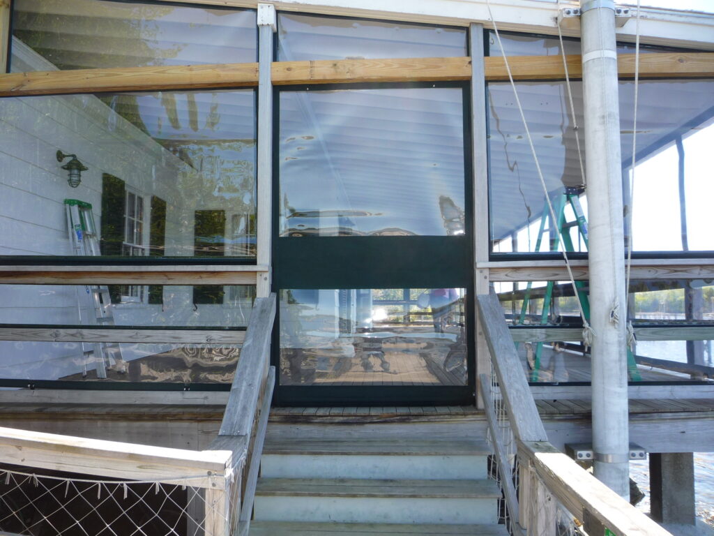 Yacht club porch with enclosure and door panel.