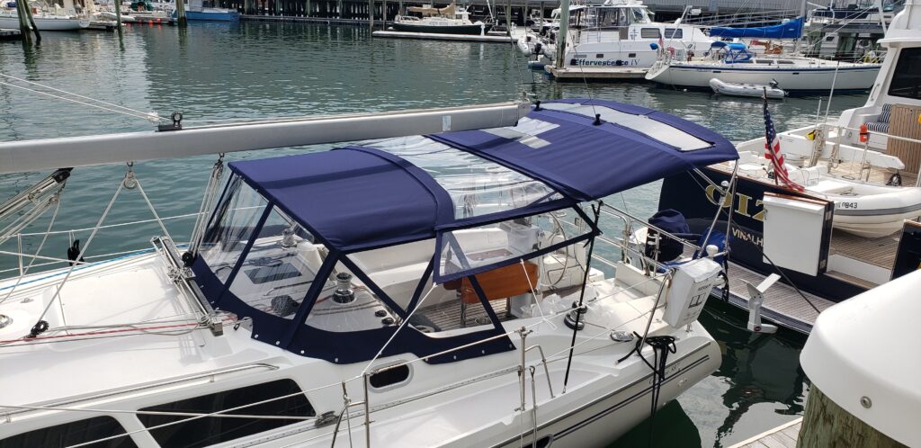 Navy dodger and bimini with clear connector to view sail.