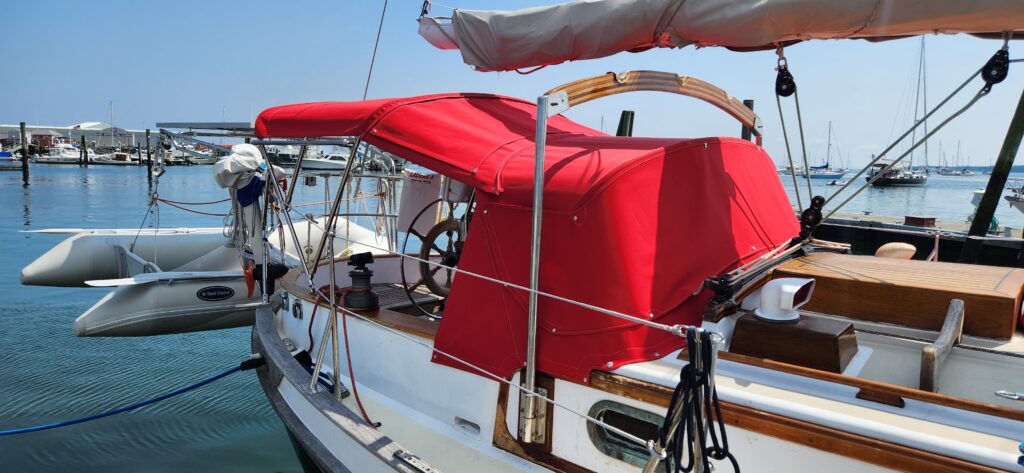 Bright red dodger/bimini/connector setup with glass covers on